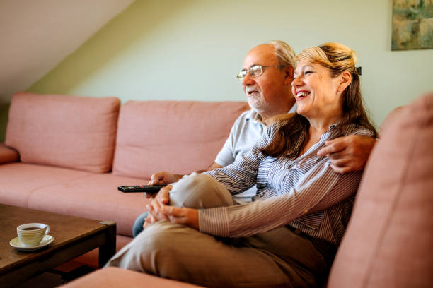 istock Senior couple watching TV at home, relaxing on a sofa 2180198646