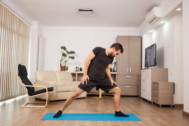 istock Bearded man doing Warrior II yoga posing and stretching his muscles 2180199732