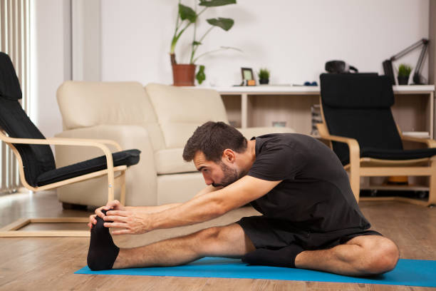istock Young man practicing yoga in his living room 2180200884