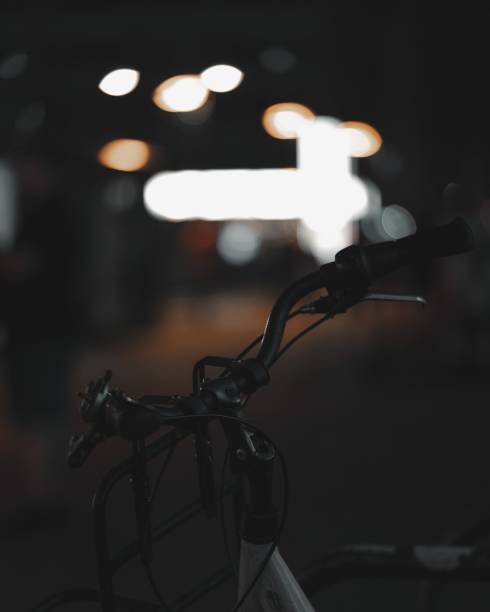 istock Closeup of a bicycle parked outdoors with bokeh lights on the blurry background 2180201123