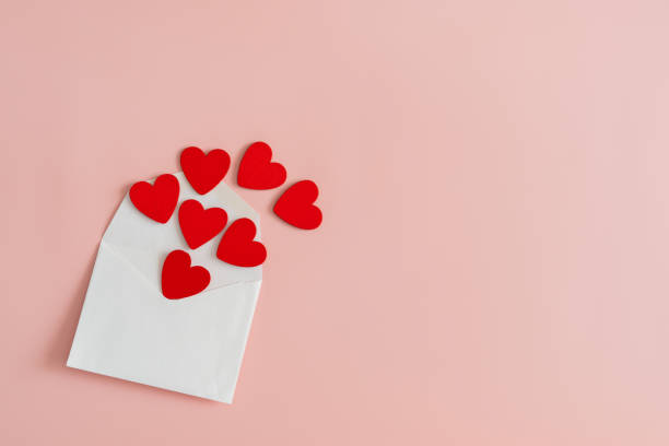 istock A white envelope with small red hearts on a pink background. Concept of love and affection. copy space 2180203196
