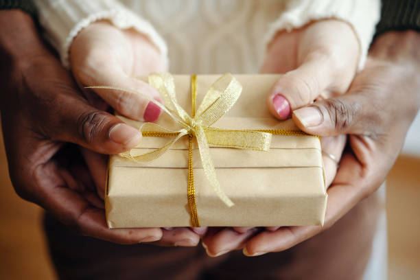 istock Young Couple Holding Present In Hands 2180203532