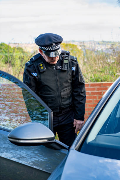 istock UK police officer approaching a parked car 2180203626