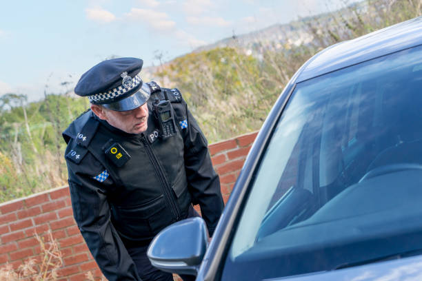 istock UK police officer approaching a parked car 2180203693