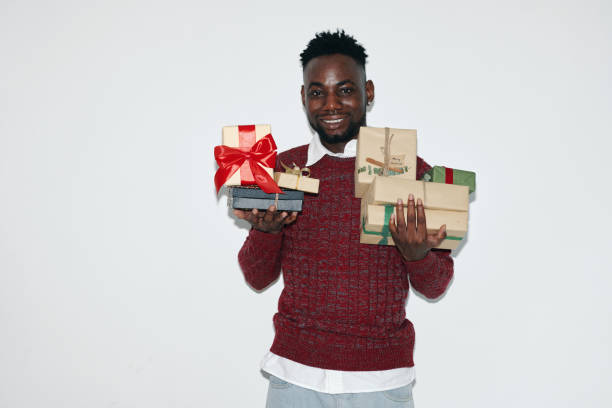 istock Portrait of Smiling Man Holding Wrapped Gift Boxes 2180203738