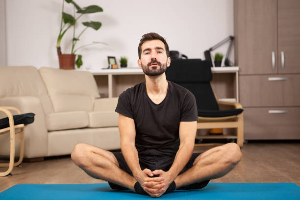 istock Young man practicing yoga in his living room 2180204714