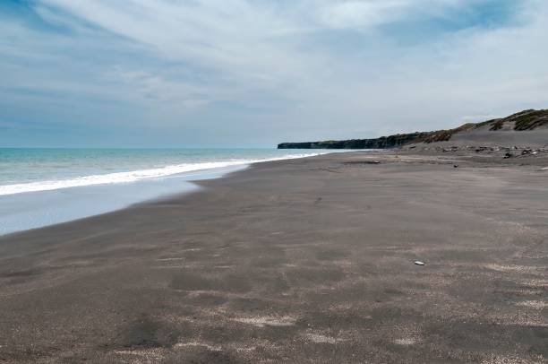 istock Serene black sand beach with gentle waves. 2180206091