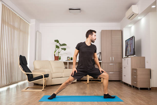 istock Bearded man doing Warrior II yoga posing and stretching his muscles 2180206918