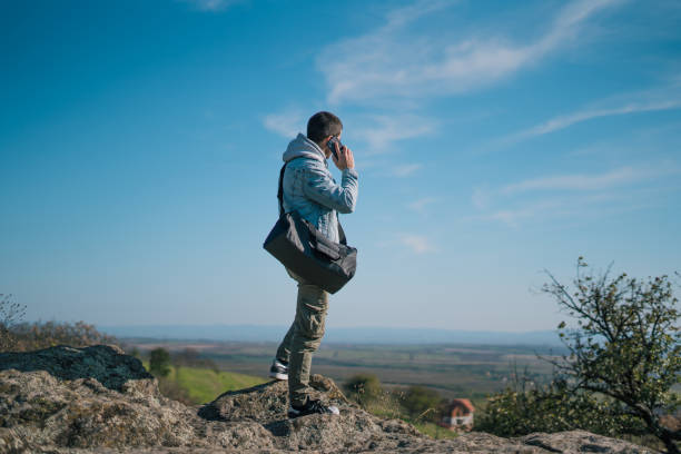 istock Capturing a beautiful view. Unrecognizable young guy with a backpack taking a photo with his smartphone - technology and travel concept 2180209137