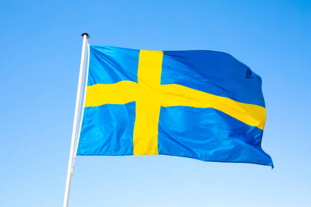 istock Swedish national flag over blue sky 2180210498
