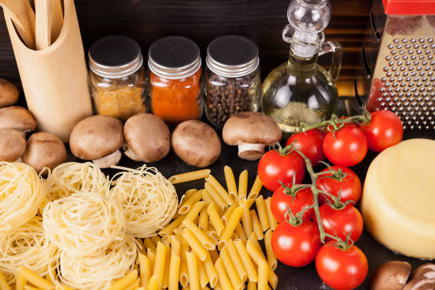 istock Uncooked raw macaroni, pasta and spaghetti next to fresh and healthy vegetables, 2180211826