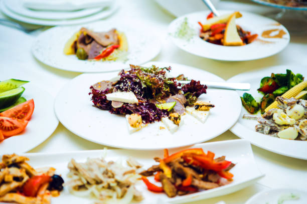 Various salads and meat on the white plates