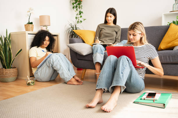 istock Flatmate student girl friends studying together using laptop to at home 2180212749