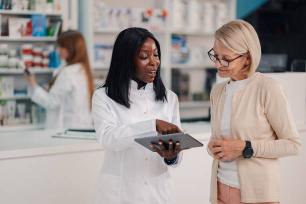 istock Friendly pharmacist showing information on tablet to senior customer in pharmacy 2180213958