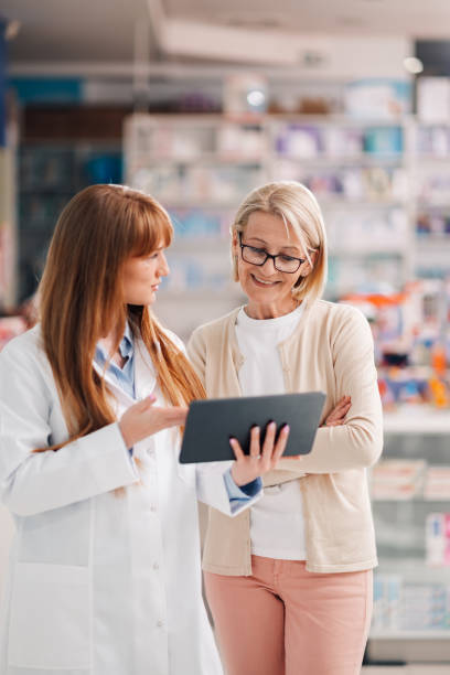 istock Pharmacist showing digital tablet to customer in pharmacy 2180213967