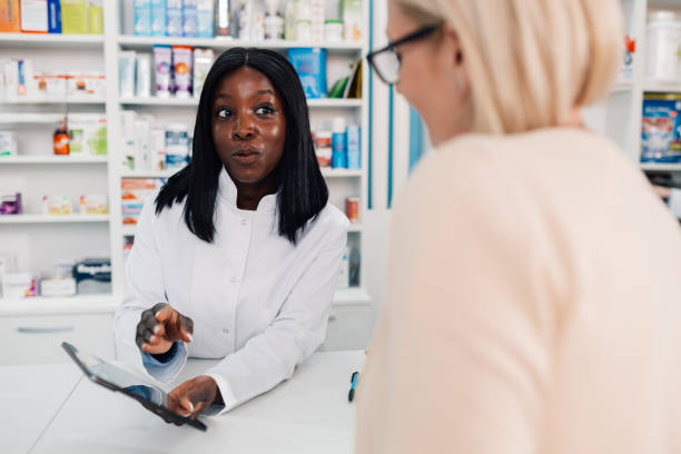 istock Pharmacist showing information on digital tablet to customer in pharmacy 2180213979