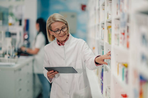 istock Senior female pharmacist using digital tablet checking medicine stock 2180214011