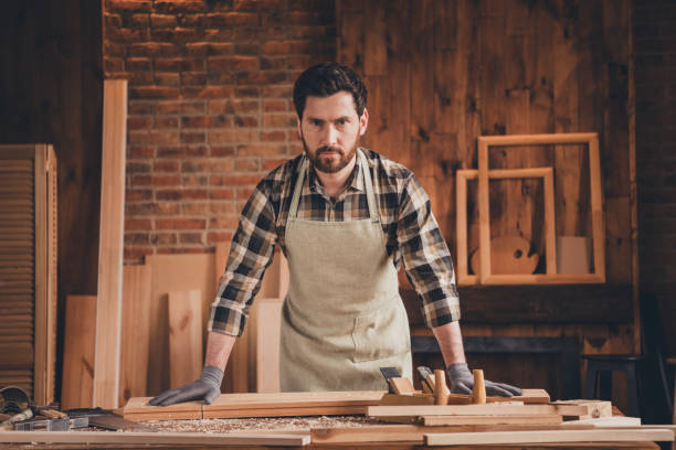 istock Photo of attractive confident carpenter dressed apron doing restoration work indoors home house garage 2180214596