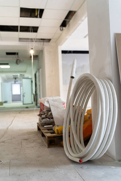 istock White plastic water hose and construction tools in the building under construction 2180218126