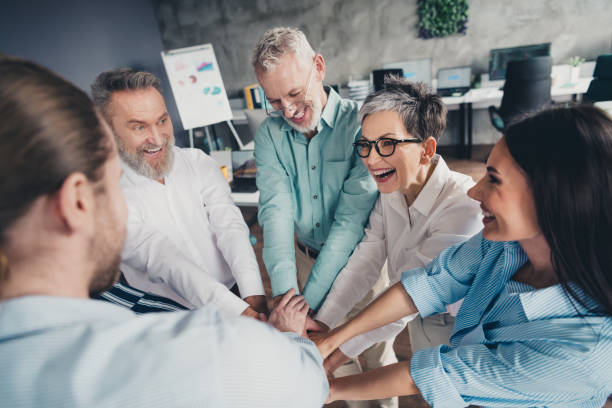 istock Photo of teamwork people working together  hold hands circle support comfortable modern office loft room interior indoors workspace 2180219985