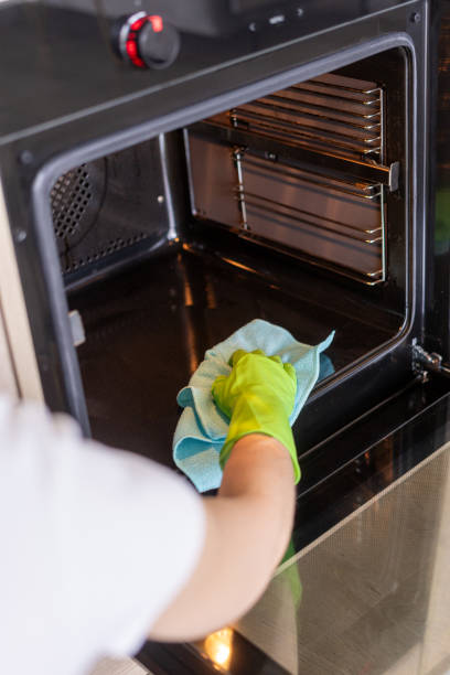 istock Woman use cloth rag washes empty electric oven inside 2180220002