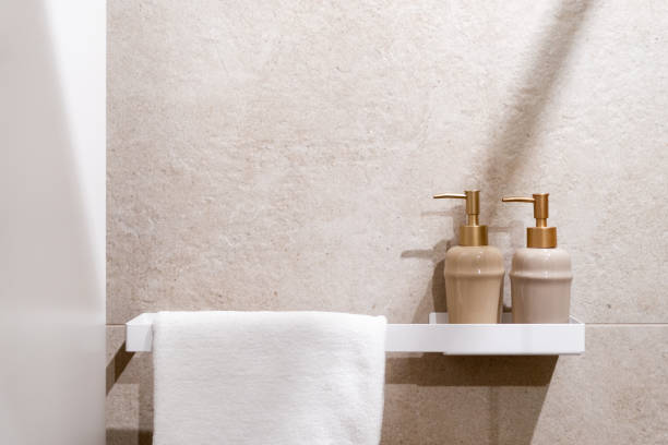 istock Two elegant soap dispensers on a shelf next to a white towel in a modern bathroom 2180221421