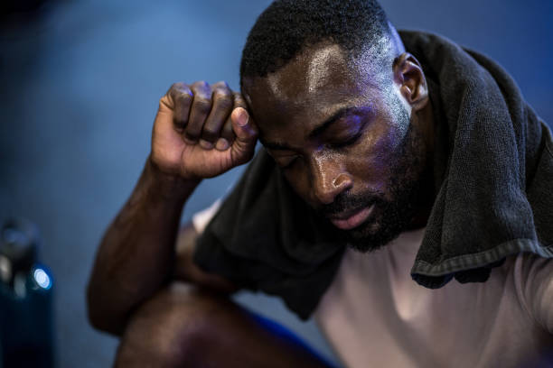 istock Exhausted athletic African American man resting from exercise in the gym. 2180225404