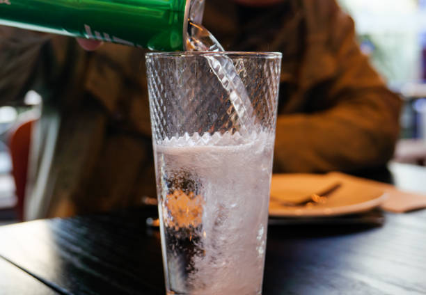 Pictured a cup of carbonated drink in a green background.