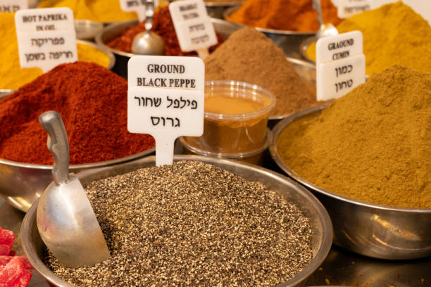 A variety of spice powders, including cumin, paprika, black pepper on sale in a spice stall in Jerusalem's Machane Yehuda outdoor market.