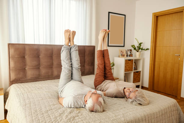 istock Active senior couple doing morning exercises on a bed in cozy apartment. 2180231641
