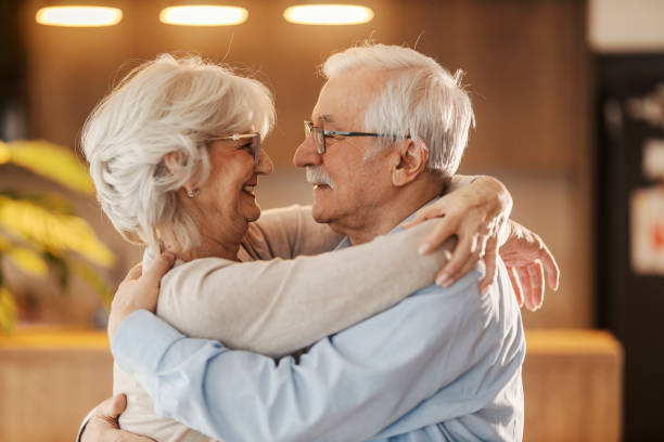 istock Affectionate senior couple is standing at home, hugging and dancing. 2180232005