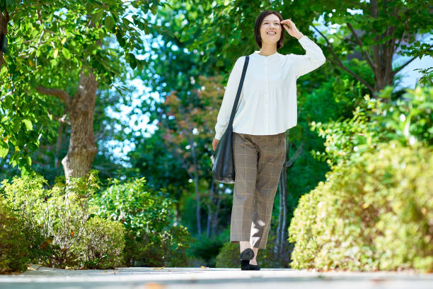 Woman walking in green space on fine day