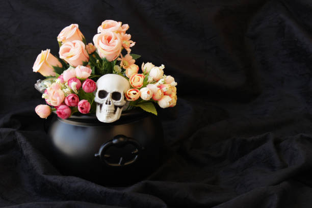 istock Halloween skull with flowers inside a black cauldron. 2180235167