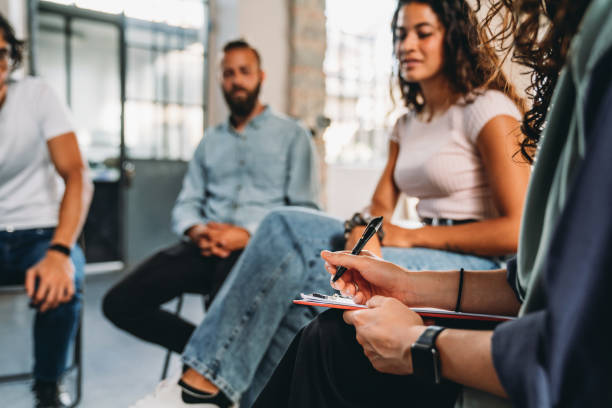 istock A mental health professional is taking notes during a group therapy session 2180235637