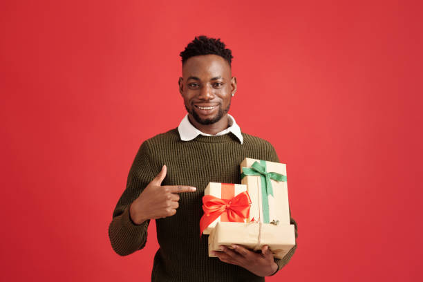 istock Portrait of Smiling Man Holding Wrapped Gift Boxes 2180236448