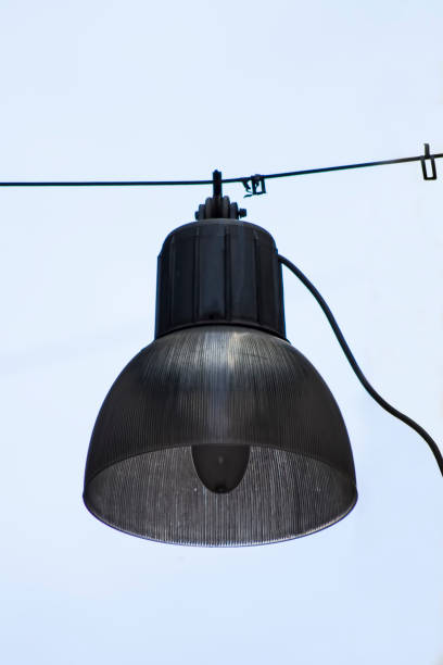 istock Elegant hanging lamp softly illuminated against a clear sky in a serene outdoor setting during golden hour 2180237359