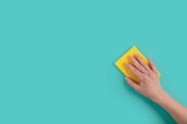 istock Woman's hand holding washing sponge on blue background 2180243287