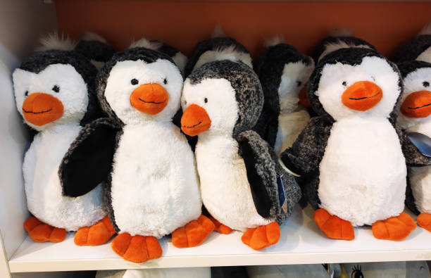 istock Soft children's plush toys white and black penguins on the shop window 2180243473