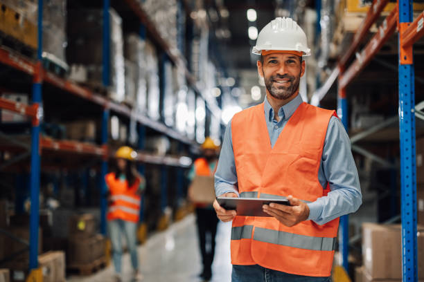 istock Warehouse manager smiling and holding digital tablet, organizing logistics and inventory 2180244629