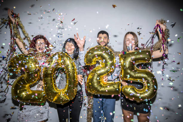 istock Joyous quartet celebrates 2025, showered with confetti joy 2180244977