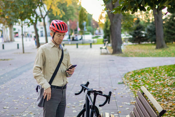 istock Smiling businessman commuter is enjoying at public park on his bicycle trip from work after a long workday. Sustainable concept of going to work by bicycle. 2180246718