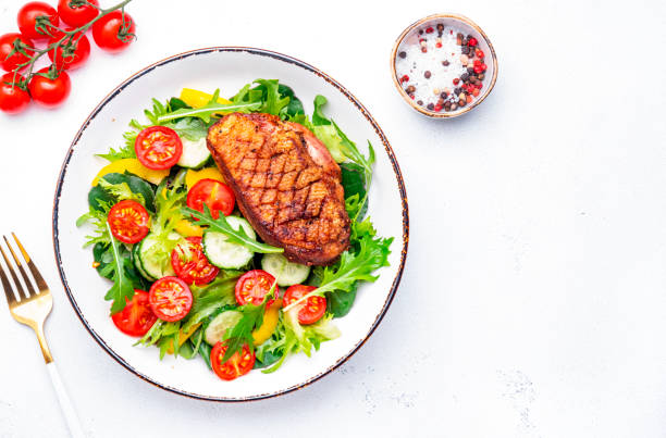istock Salad with duck breast, lettuce and vegetables, white background, top view 2180248838