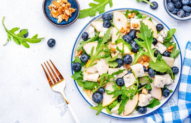 istock Salad with pear, blueberries, blue cheese, arugula and walnuts. White background, top view 2180248855