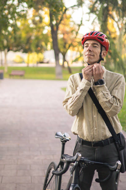 istock Smiling businessman commuter is enjoying at public park on his bicycle trip from work after a long workday. Sustainable concept of going to work by bicycle. 2180249363