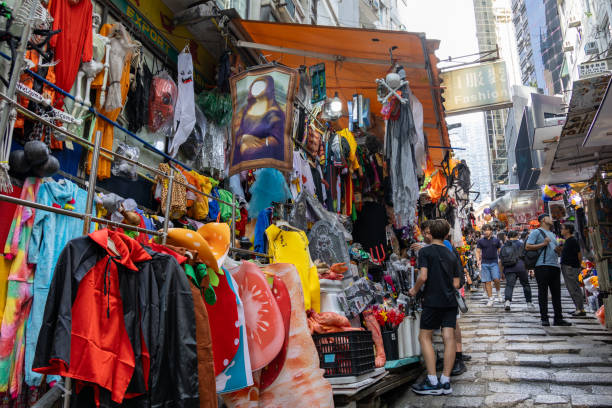 Hong Kong - October 22, 2024 : Pedestrians walk past street stalls selling decorations and costumes for the upcoming Halloween in Central, Hong Kong.