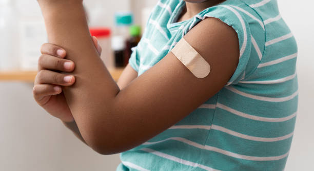 istock child showing his band aid on his arm after vaccination 2180251117