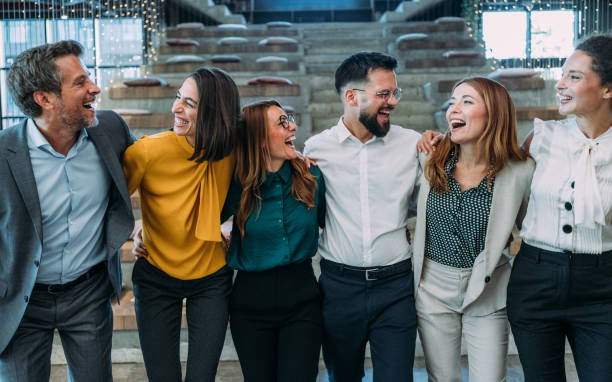 istock Excited coworkers embracing each other during a celebration in the office. 2180253917