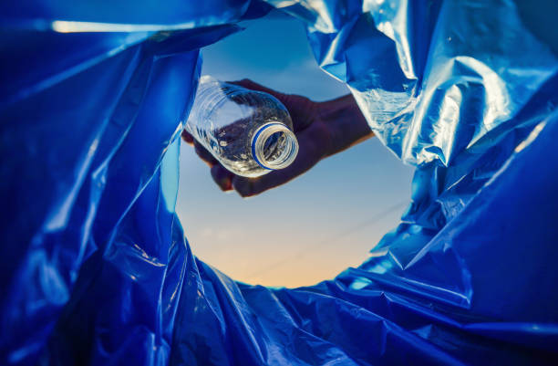 istock Throwing plastic bottle. Hand throwing bottle in trash cans. 2180255602