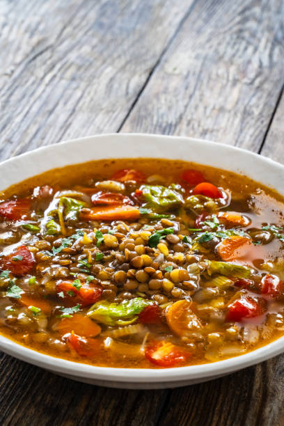 istock Fresh vegetable soup with lentil served in white bowl on wooden table 2180255848
