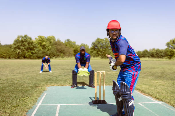 istock Cricket Match Action: Batsman, Wicketkeeper, and Bowler in Play 2180256190